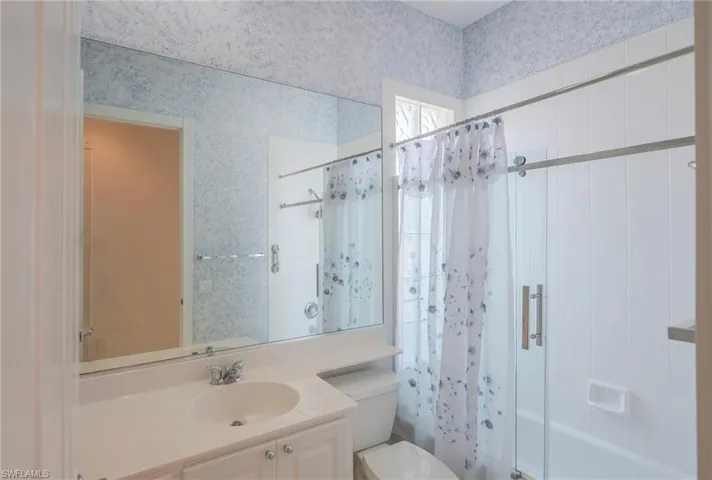 Bathroom with shower / bath combination with curtain and vanity