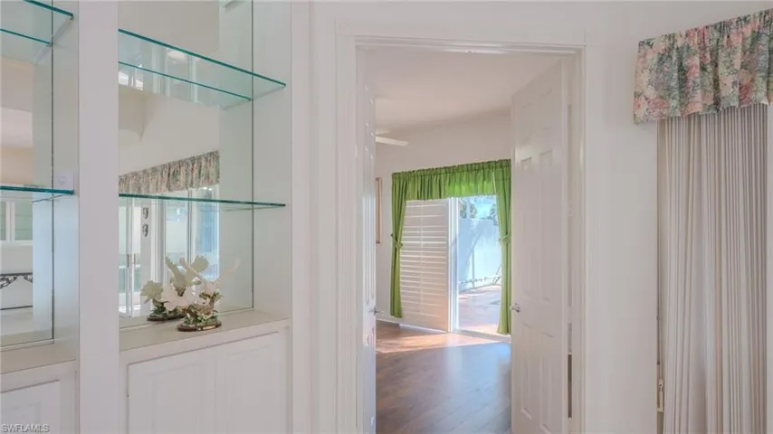 Hall with wood finished floors and healthy amount of natural light