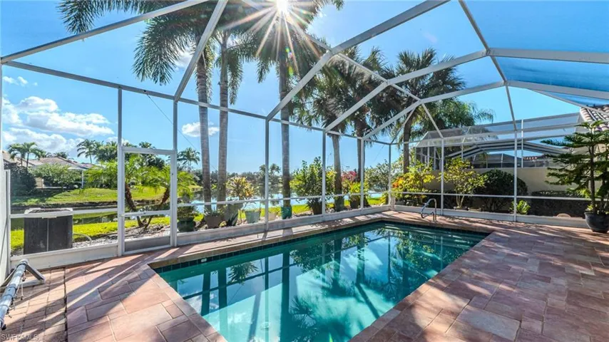 Outdoor pool with a sunroom and glass enclosure