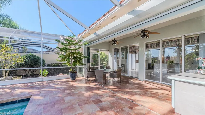 View of patio / terrace featuring a sunroom, a lanai, outdoor dining space, and ceiling fan