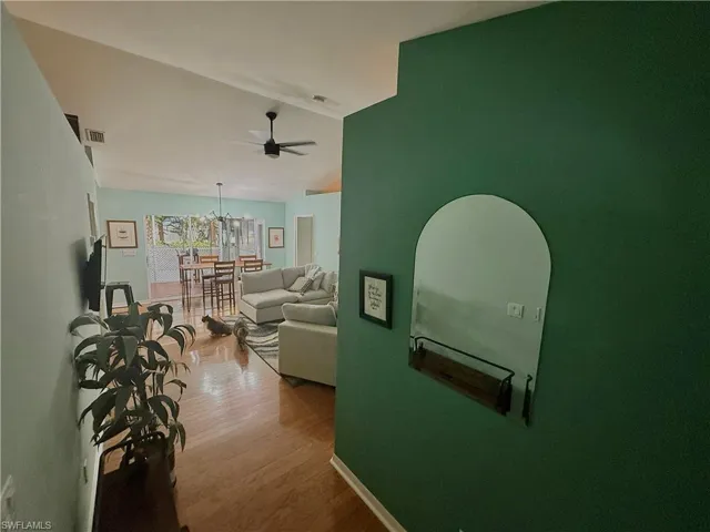 Hallway featuring vaulted ceiling and wood finished floors