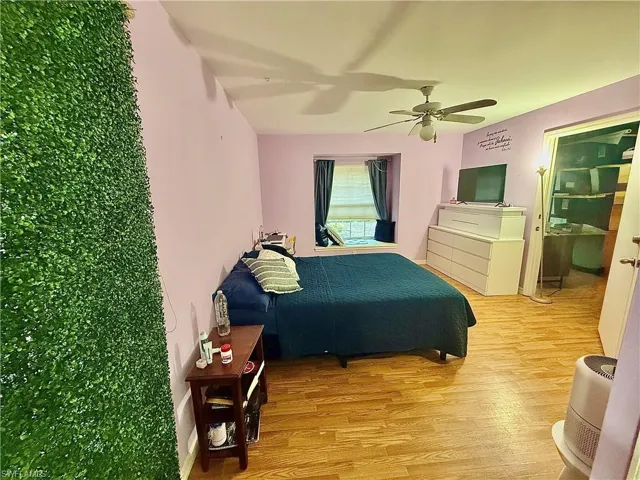 Bedroom with a ceiling fan and light wood-style floors