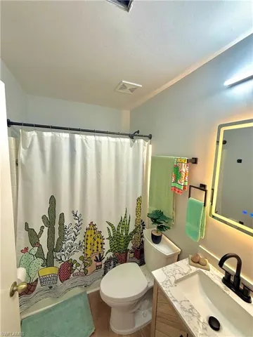 Full bath featuring vanity and curtained shower