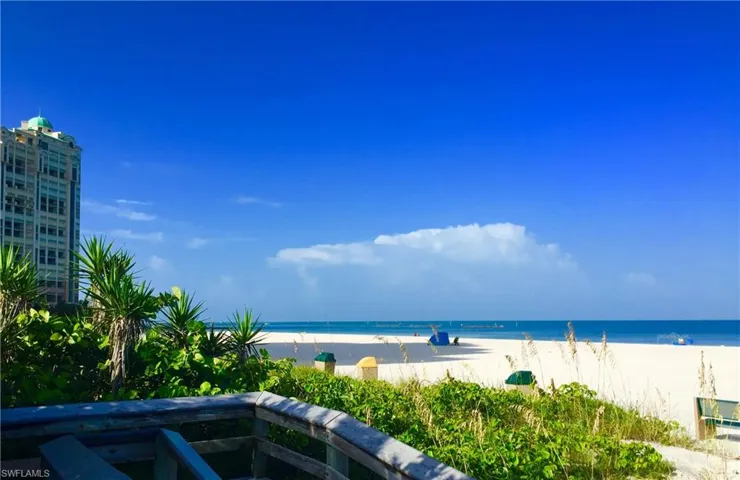 Coastal landscape featuring a wooden boardwalk, white sand beach, and oceanfront proximity