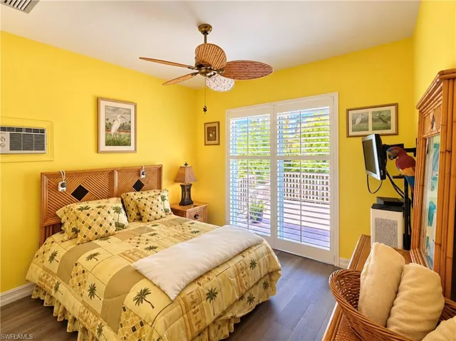 Wood-finish flooring, dual-panel sliding glass doors with plantation shutters, and a ceiling fan with palm-style blades