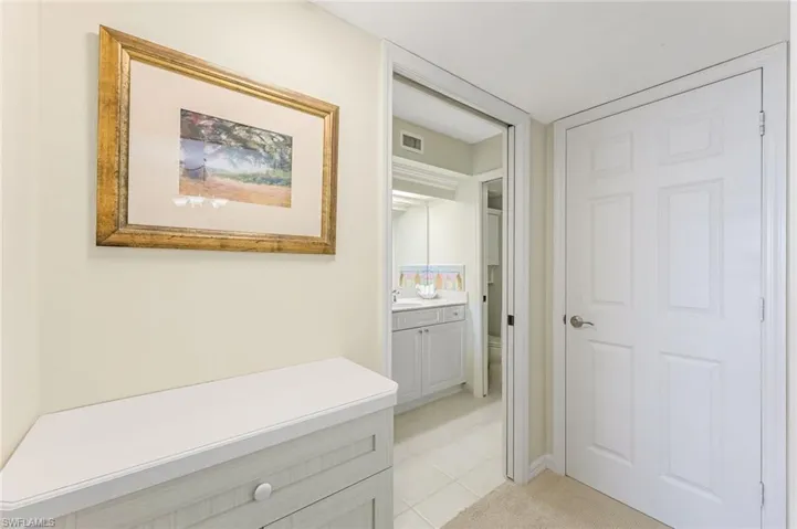 Hallway with a sink and light tile patterned floors