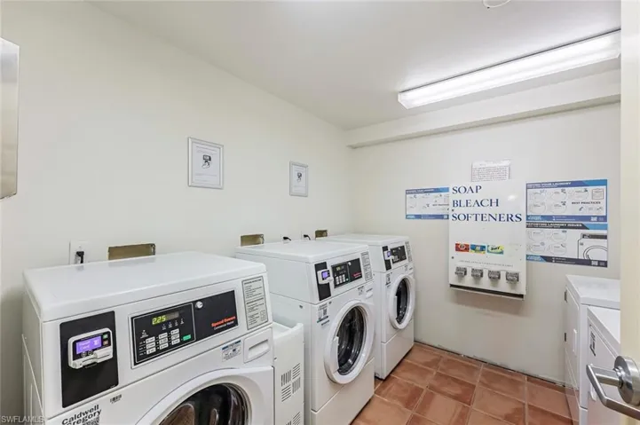 Community laundry featuring washer and dryer and light tile patterned floors