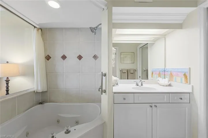 Full bath featuring vanity and a combined bath / shower with jetted tub