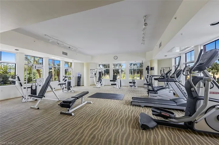 Gym with rail lighting, carpet, and baseboards