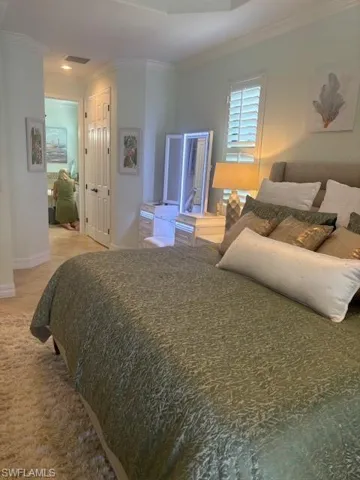 Bedroom with ornamental molding and a closet