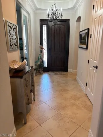 Entryway featuring crown molding and a chandelier