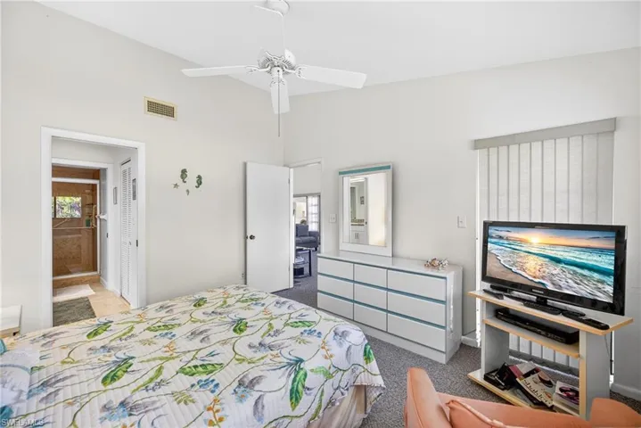 Primary bedroom with ensuite bath and a ceiling fan