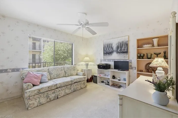Living area with light carpet, wallpapered walls, and ceiling fan