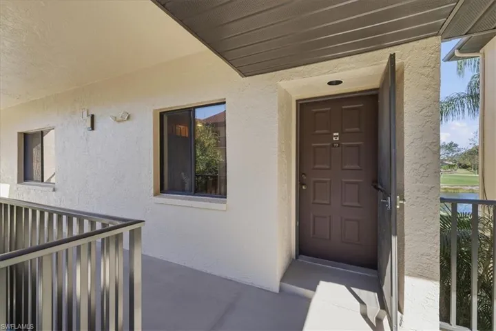 Property entrance with stucco siding and screen door