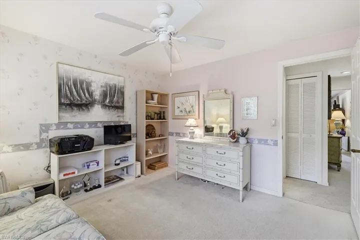 Bedroom with light carpet and a ceiling fan
