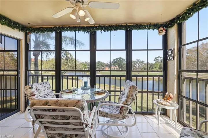 Sunroom with tile patterned floors, plenty of natural light, and a water view