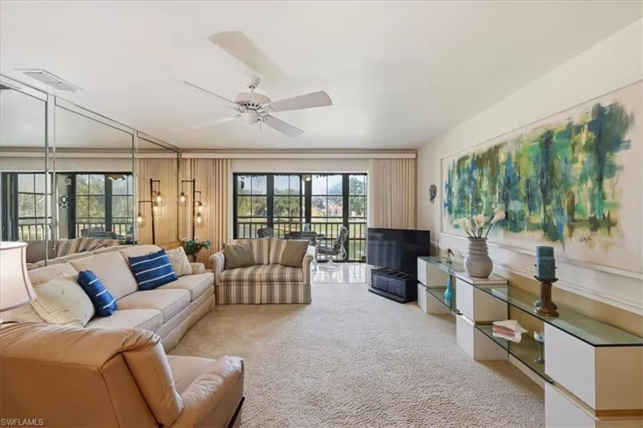 Living room with a ceiling fan and light carpet