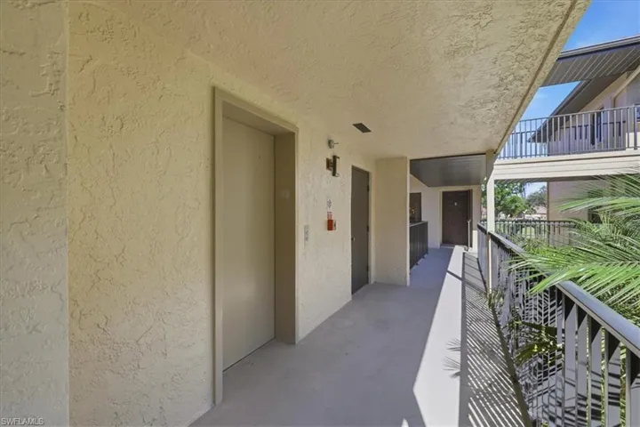 Property entrance with stucco siding and screen door