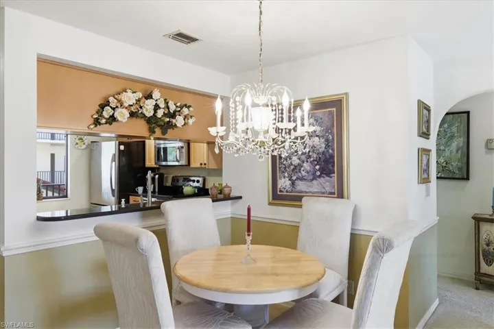 Dining space with a chandelier and light carpet