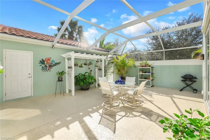 View of Lanai with Sitting Area, Arbor and both the Garage and Side Yard Service Doors