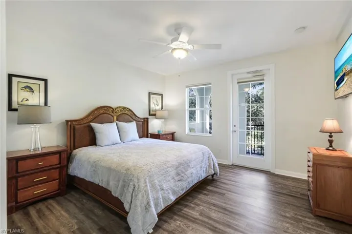 Primary Bedroom featuring Luxury Vinyl Plank Flooring, Ceiling Fan and Access to the Exterior Screened Balcony