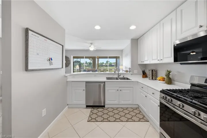 Bright kitchen with gas range, white cabinetry, and ample counter space