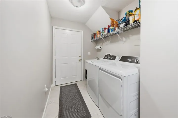 Laundry room with washer, dryer, and storage