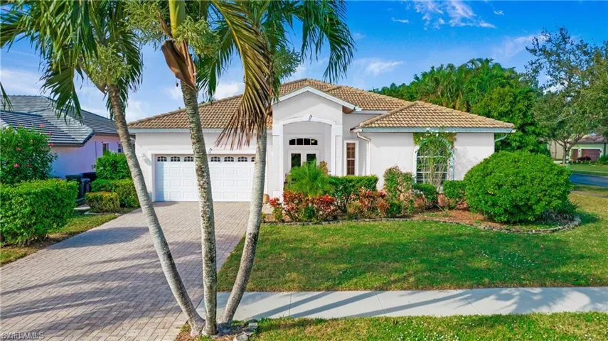 Mediterranean / spanish-style home featuring a front yard and a garage