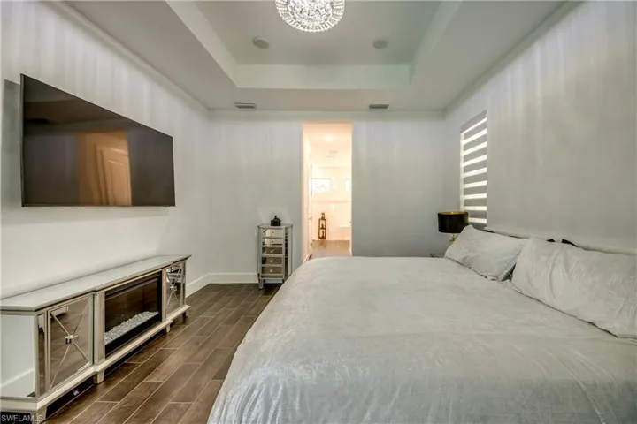 Bedroom featuring wood tiled floors and a tray ceiling