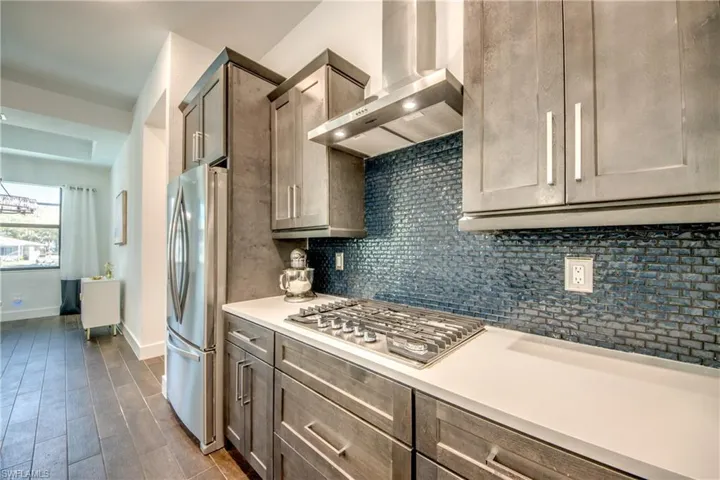 Kitchen with stainless steel appliances, tasteful backsplash, and dark wood-style floors