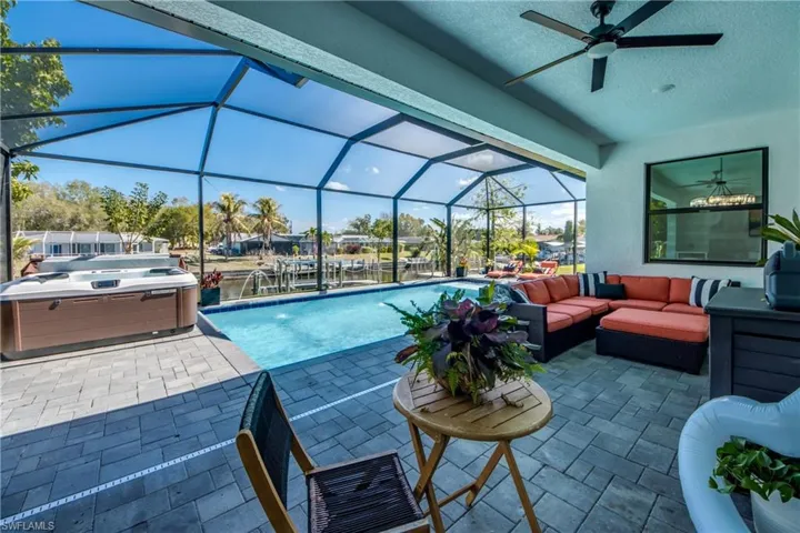 Swimming pool featuring outdoor lounge area, a hot tub, a patio, and a lanai