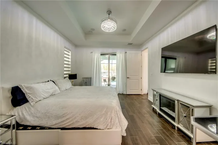 Bedroom with dark wood-style flooring and access to outside