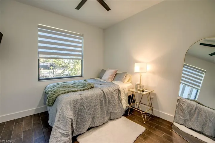 Bedroom with wood tiled floors, ceiling fan, and arched walkways