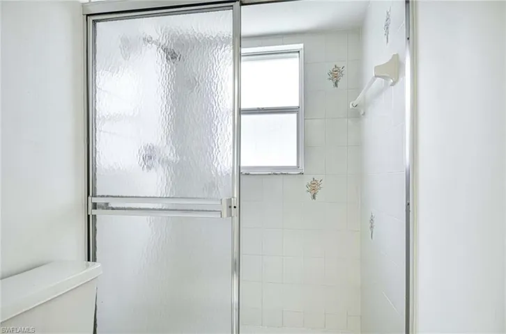 Full bath with a shower stall and toilet