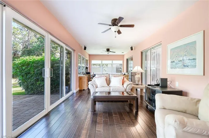 Sunroom / solarium with wood-type flooring and french doors