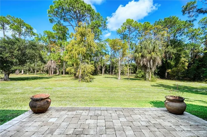 View of green lawn with a patio area