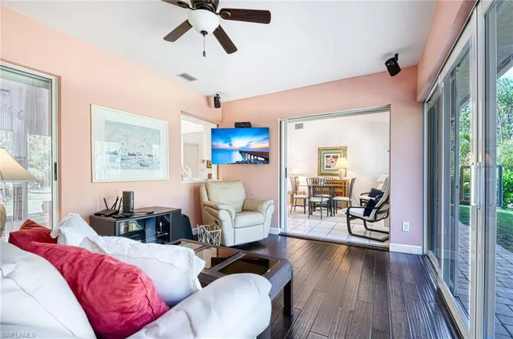 Living area featuring ceiling fan and dark wood-style flooring