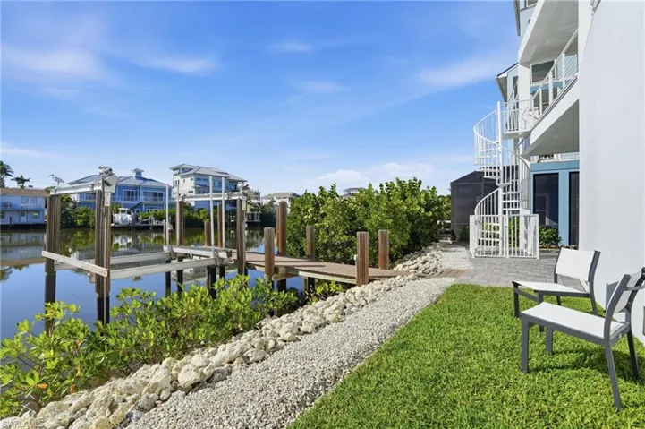 Composite dock with lift, spiral staircase leading to elevated outdoor living, pool and spa.