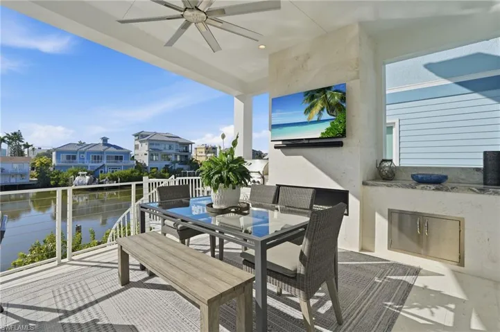 Outdoor gas grill, fireplace, cabinetry, television.