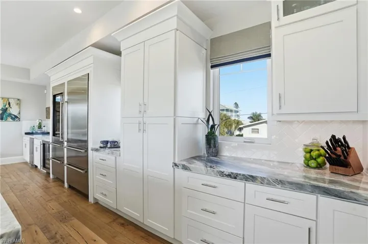 Custom cabinetry, Quartzite countertops, Sub-Zero tall wine fridge, Sub-Zero refrigerator, pantry with pull out drawers.