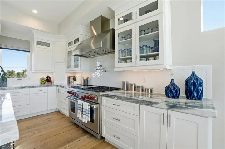 Custom cabinetry with glass inserts, Wolf gas range, Wolf rangehood.