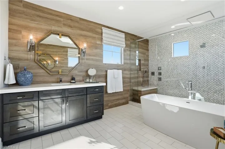 Dual vanities, wall sconces, custom cabinetry, soaking tub, designer tile finishes.