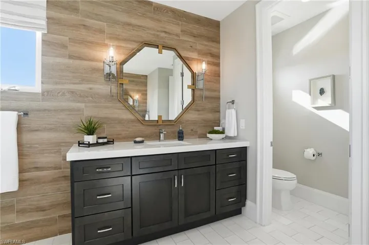 Dual vanities, custom cabinetry, wall sconces, private water closet.