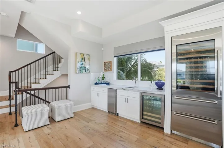 Effortless entertaining. Wet bar features U-line built in ice maker, beverage center, Sub-Zero tall wine fridge. Wrought iron staircase leading to all 4 floors.