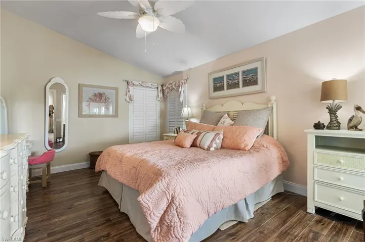 Bedroom with wood finished floors, vaulted ceiling, and ceiling fan