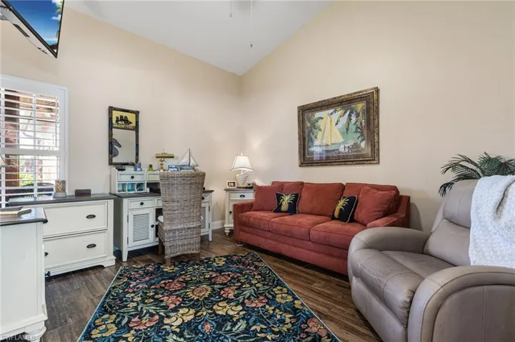 Living room with dark wood finished floors and high vaulted ceiling