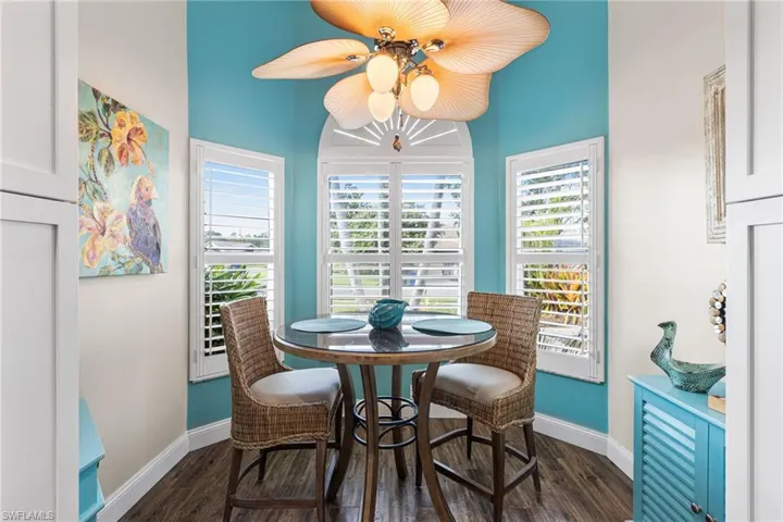 Dining area with dark wood-type flooring and ceiling fan