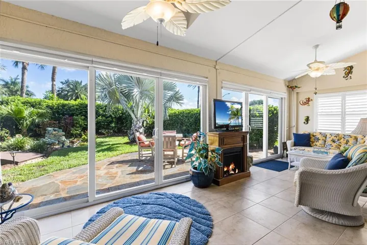 Sunroom / solarium featuring tile patterned floors, healthy amount of natural light, and vaulted ceiling