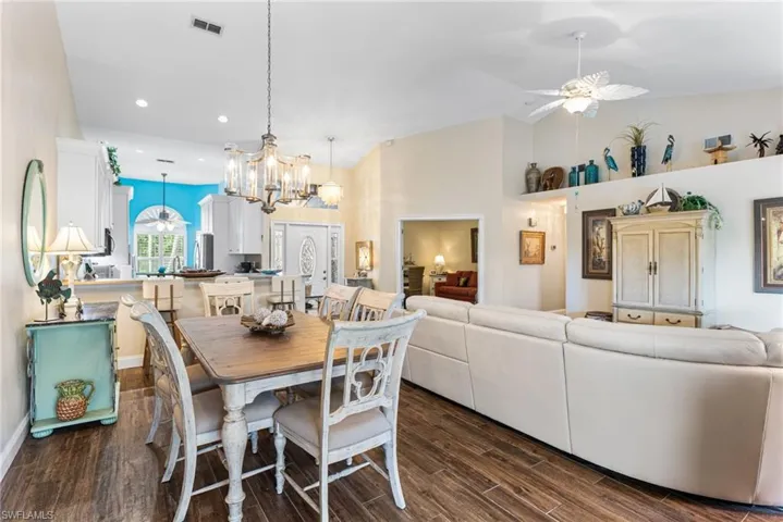 Dining area with a chandelier, a ceiling fan, dark wood finished floors, and recessed lighting