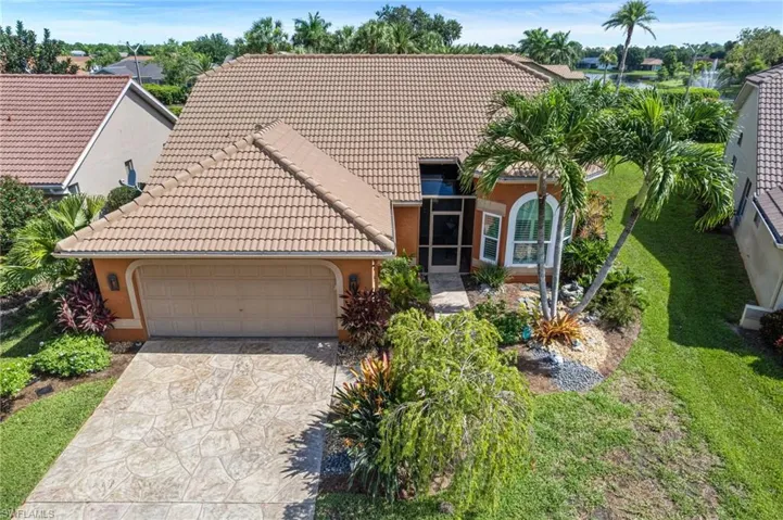 Mediterranean / spanish home featuring a tile roof, a garage, concrete driveway, stucco siding, and a front lawn